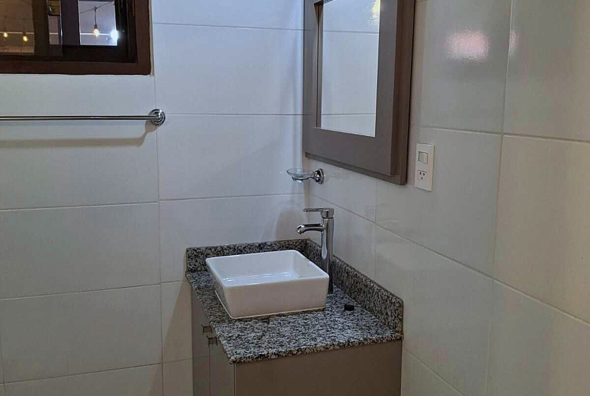 Modernes Badezimmer in Paraguay mit elegantem Waschtisch, Granitplatte, Spiegel und weißen Fliesen für stilvolles Wohnen.