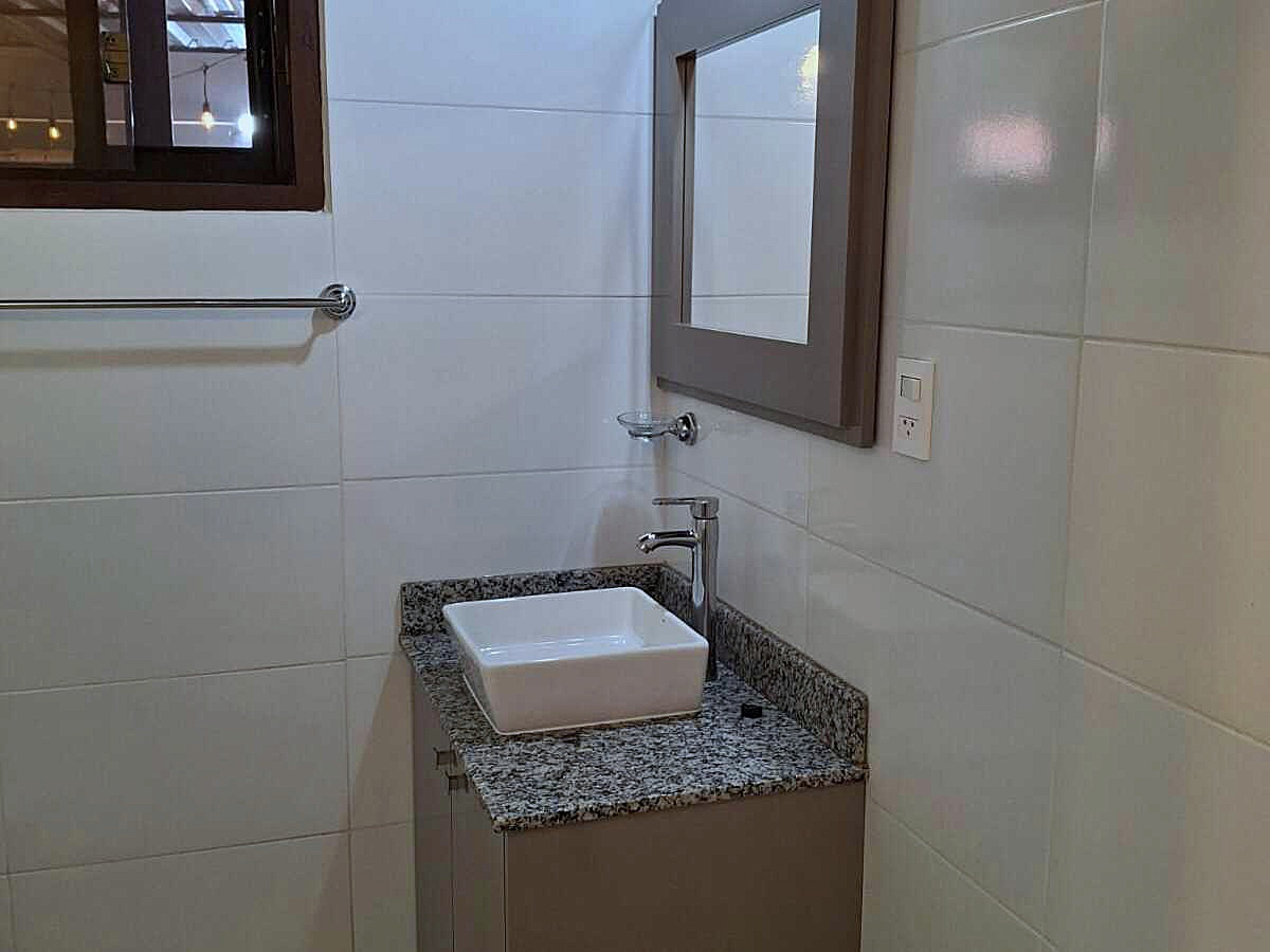 Modernes Badezimmer in Paraguay mit elegantem Waschtisch, Granitplatte, Spiegel und weißen Fliesen für stilvolles Wohnen.