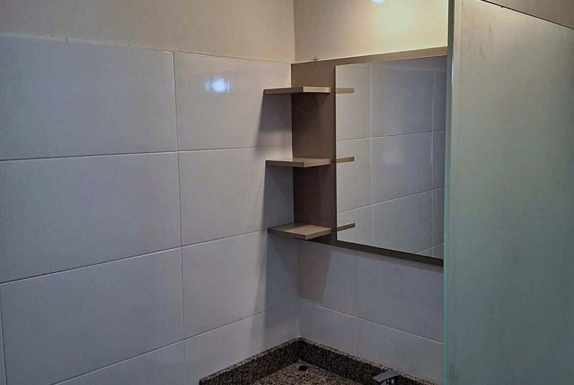Modernes Badezimmer in Paraguay mit elegantem Granitwaschtisch, großem Spiegel und praktischen Regalen.