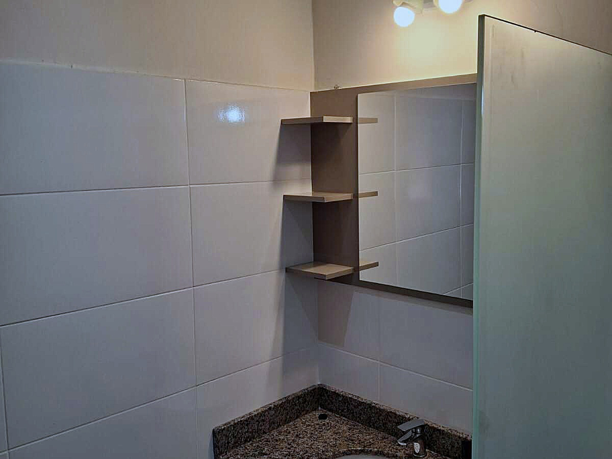 Modernes Badezimmer in Paraguay mit elegantem Granitwaschtisch, großem Spiegel und praktischen Regalen.