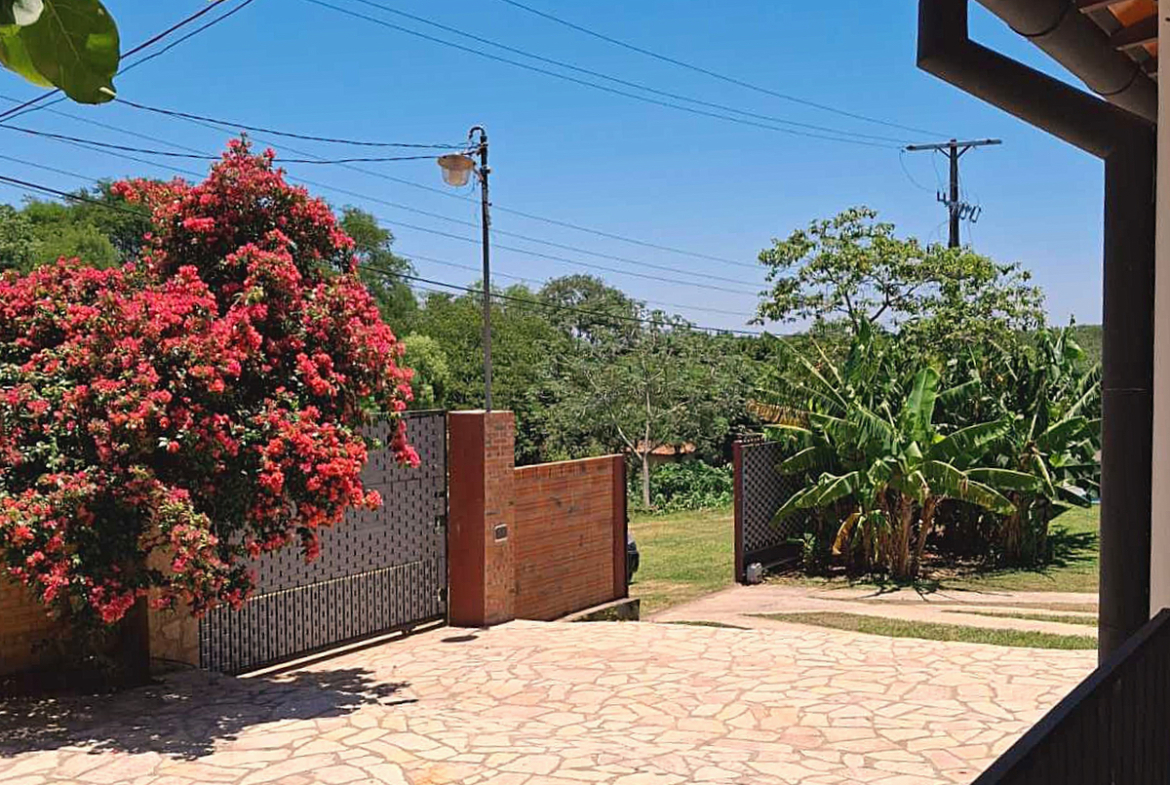 Einladende Einfahrt mit prächtiger Bougainvillea und tropischem Garten einer Immobilie in Paraguay.