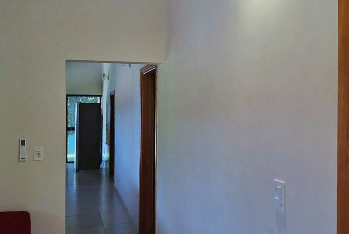 Heller Flur in moderner Immobilie in Paraguay mit Holztüren und Blick in den Garten.