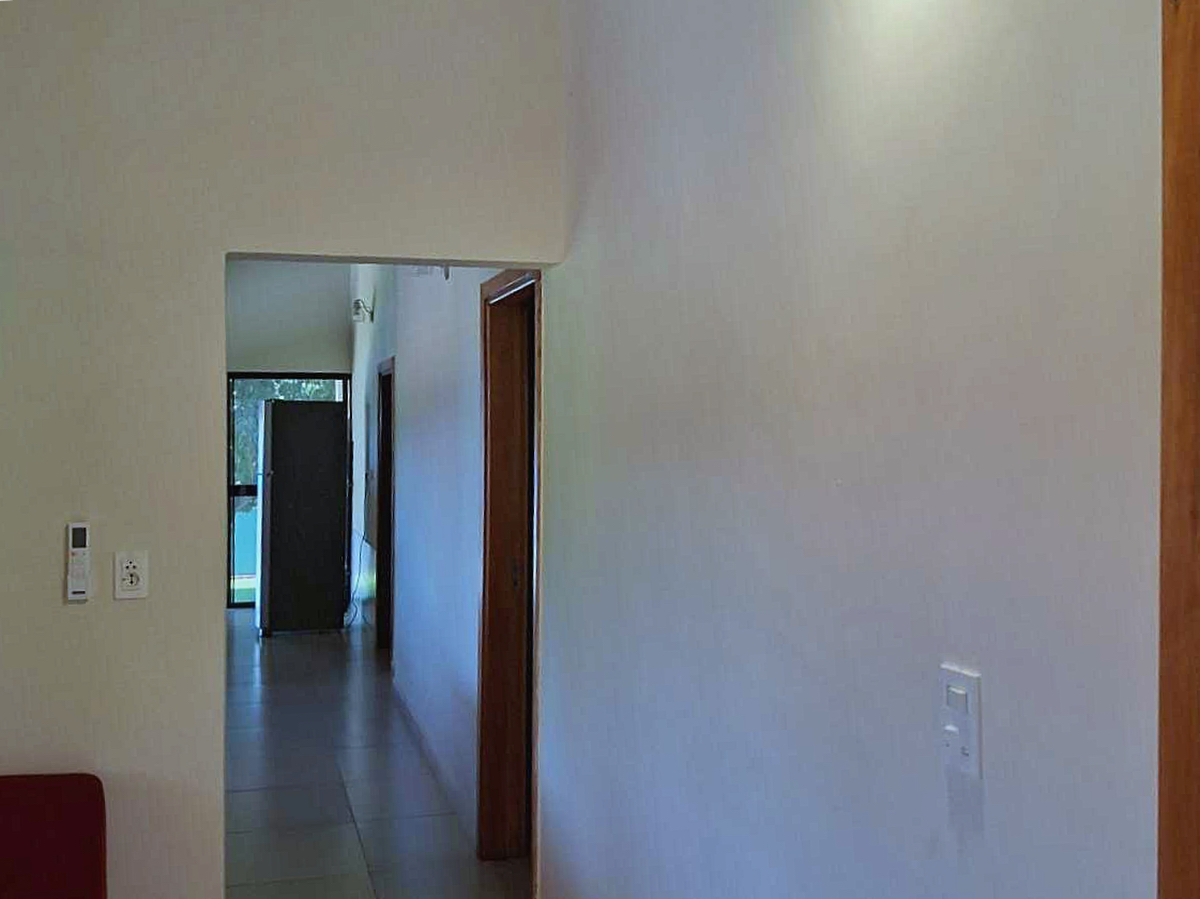 Heller Flur in moderner Immobilie in Paraguay mit Holztüren und Blick in den Garten.