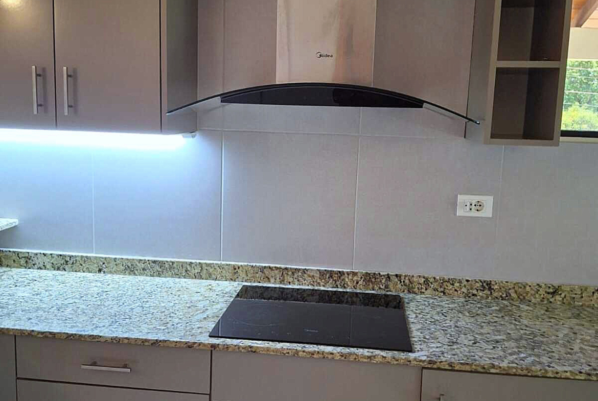 Moderne Einbauküche in Paraguay mit eleganter Granit-Arbeitsplatte, Induktionskochfeld und LED-Beleuchtung.