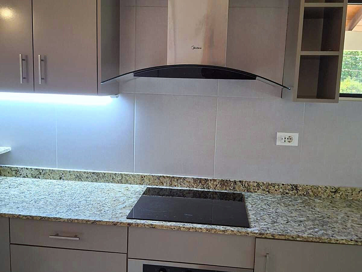 Moderne Einbauküche in Paraguay mit eleganter Granit-Arbeitsplatte, Induktionskochfeld und LED-Beleuchtung.