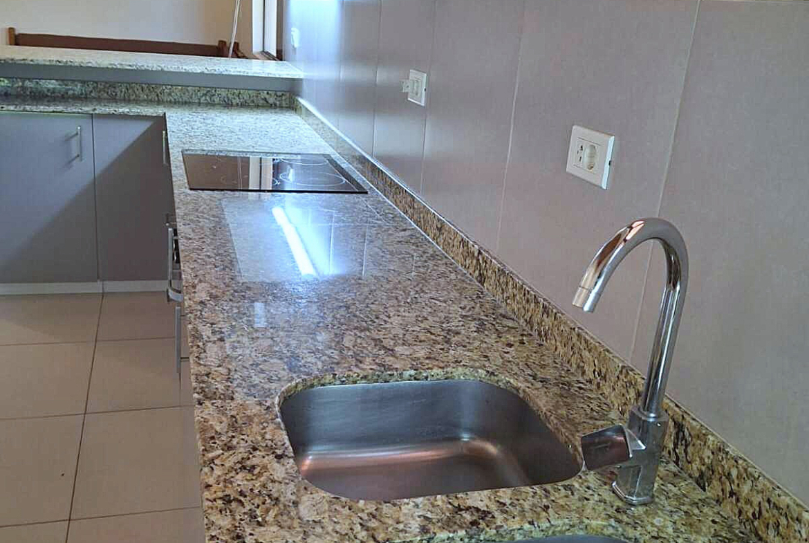 Moderne Küche in Paraguay mit Granitarbeitsplatte, Spüle und Induktionskochfeld.