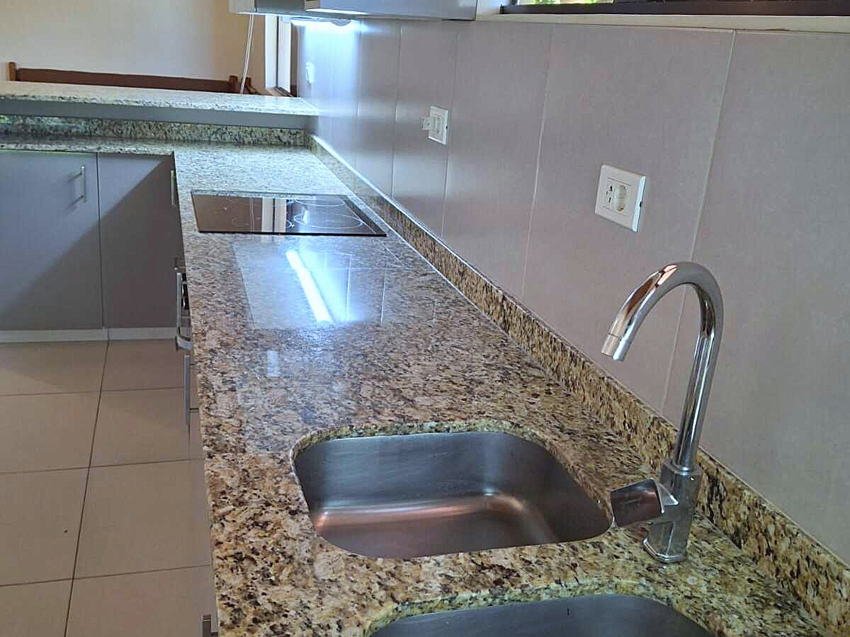 Moderne Küche in Paraguay mit Granitarbeitsplatte, Spüle und Induktionskochfeld.