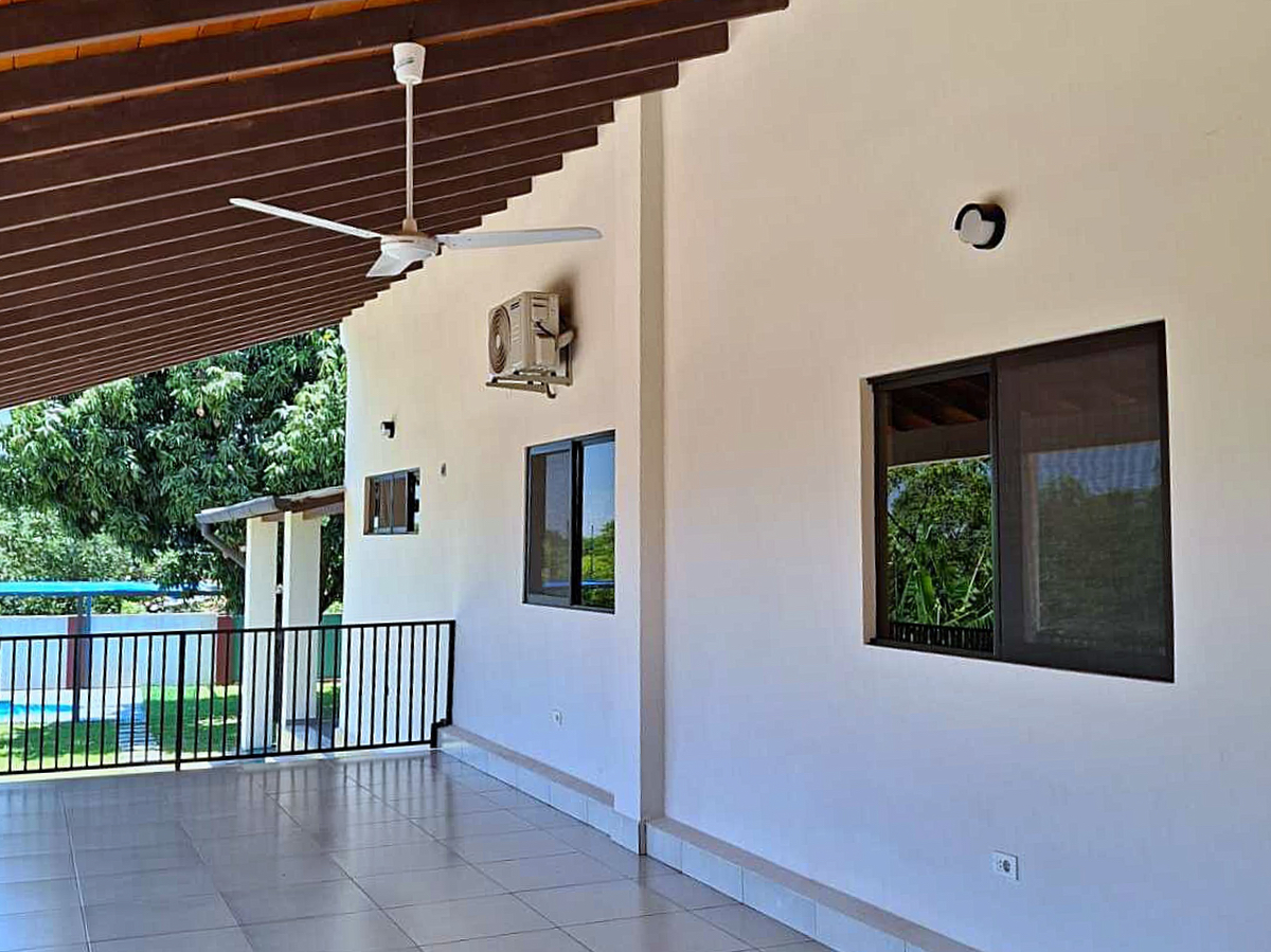 Überdachte Terrasse mit Deckenventilator, Klimaanlage und Grünblick am Haus in Paraguay.