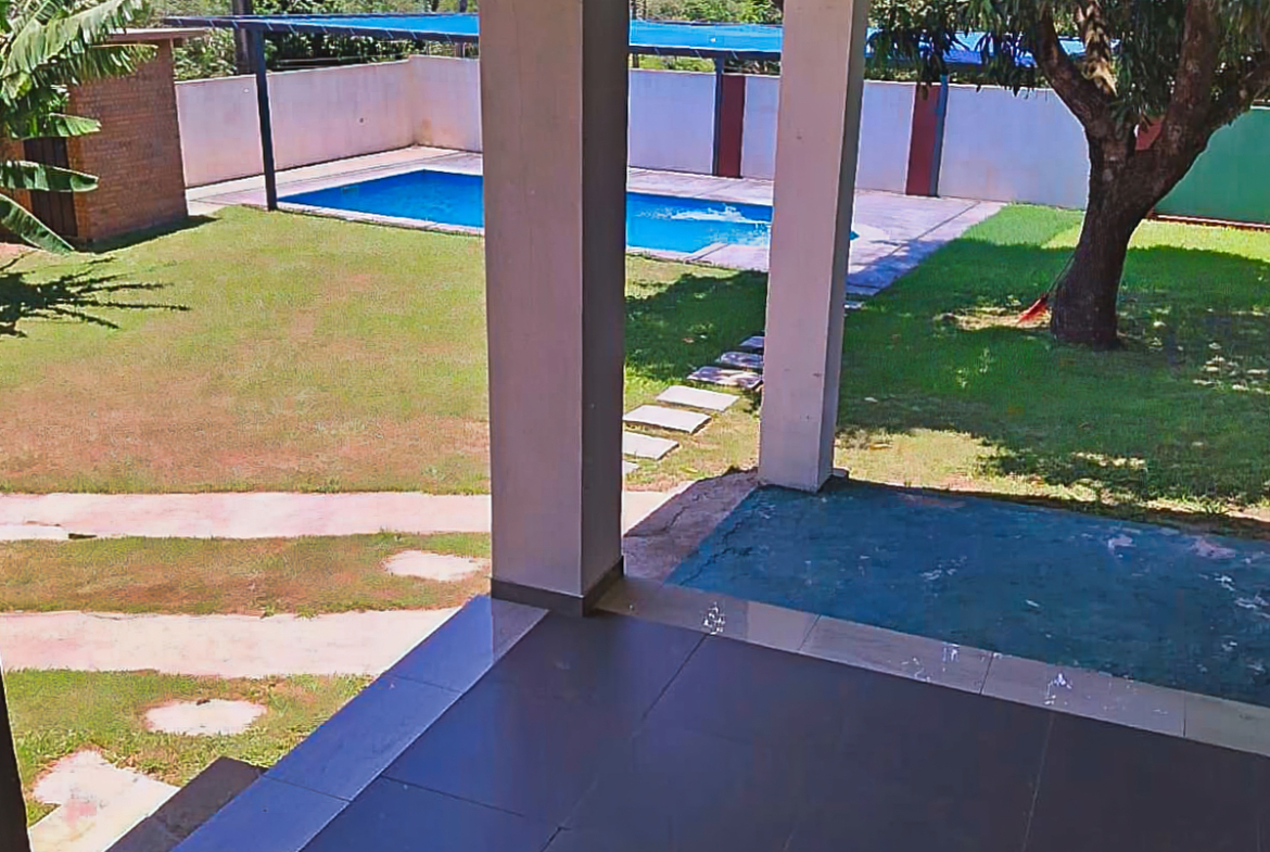 Dieses Immobilienfoto aus Paraguay zeigt einen großen Garten mit Pool und sonniger Terrasse zum Entspannen.