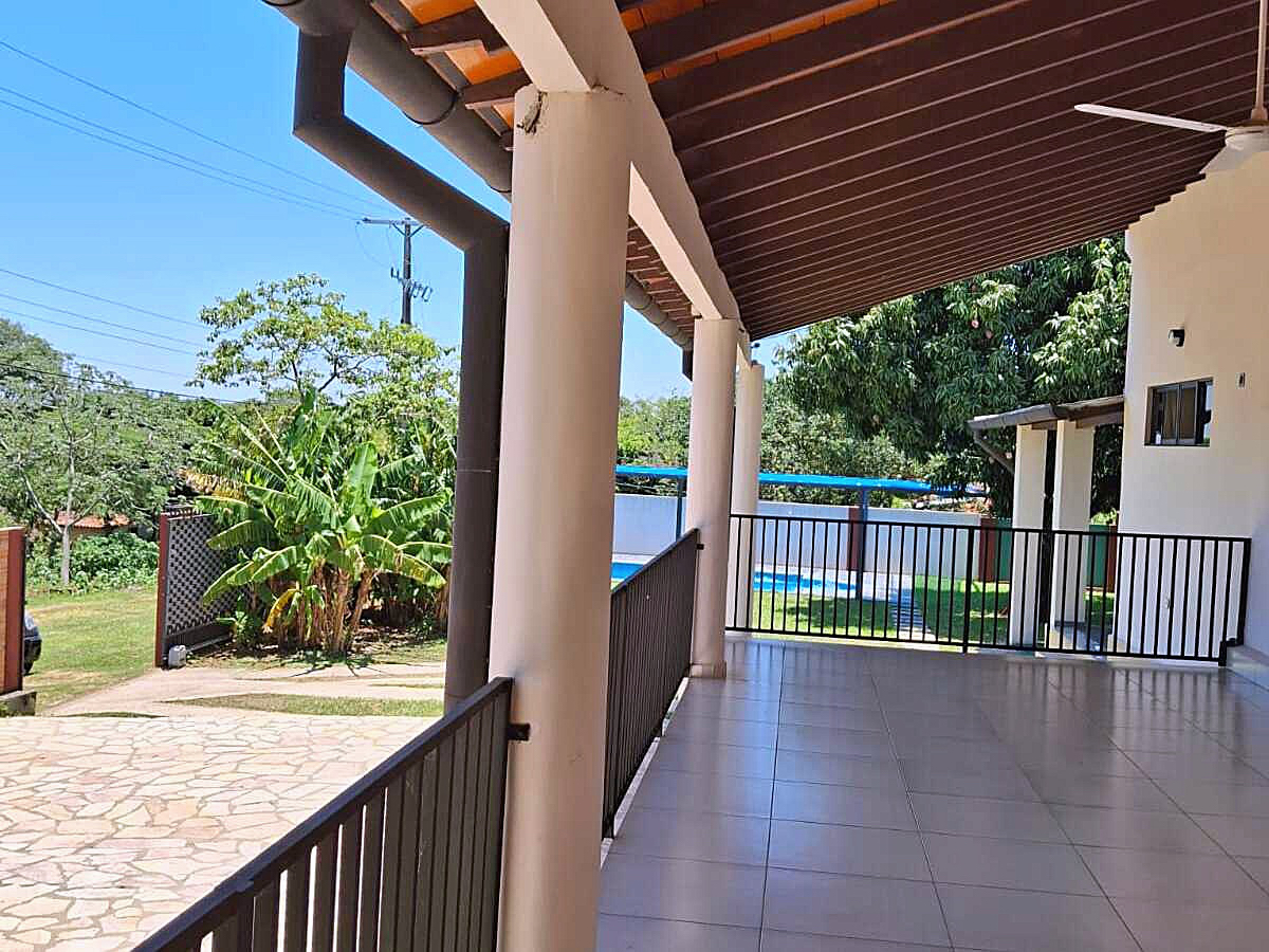 Geräumige überdachte Terrasse eines Hauses in Paraguay mit Blick auf den Garten und Pool.