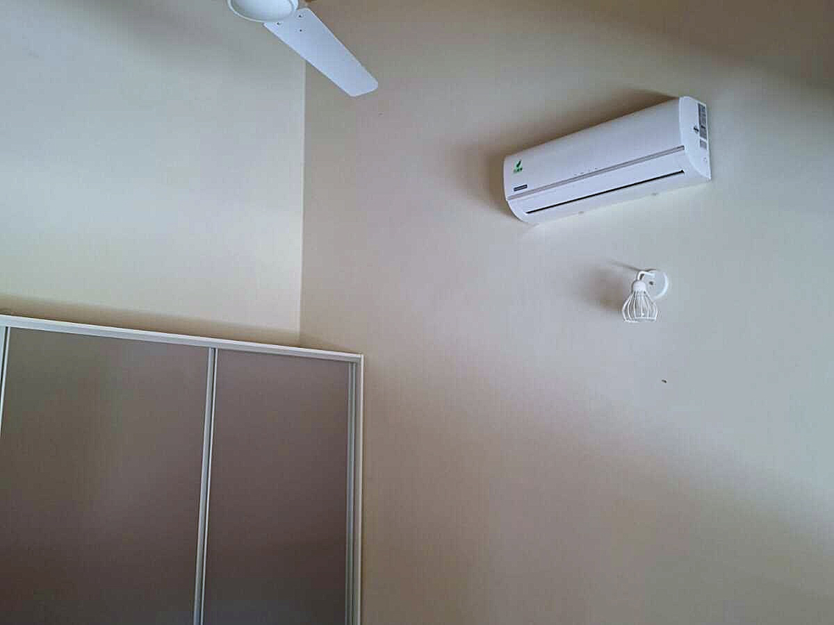 Modernes Schlafzimmerdetail in Paraguay mit Klimaanlage, Deckenventilator und praktischem Einbauschrank für Komfort.