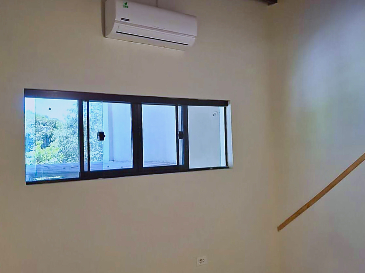 Heller Wohnraum in Paraguay mit Klimaanlage, Fensterblick ins Grüne und moderner Ausstattung.
